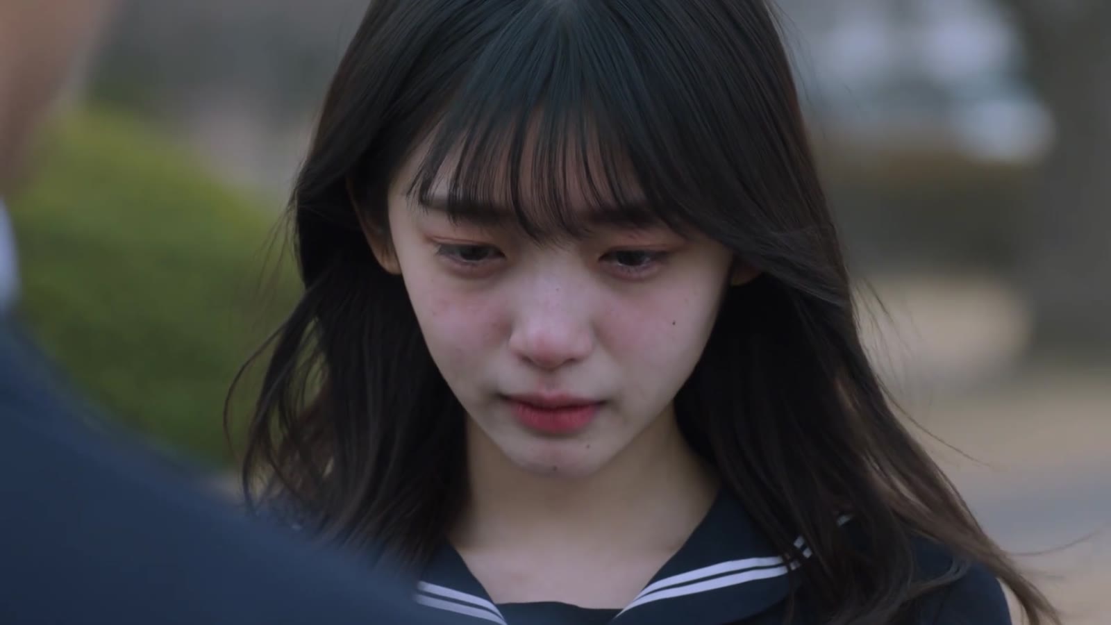 案例中间帧:年轻女性低头并短暂闭眼